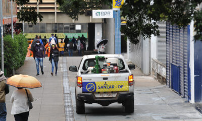 Registro do Setor Comercial Sul com pessoas caminhando e, ao lado, um veículo da SANEAR-DF