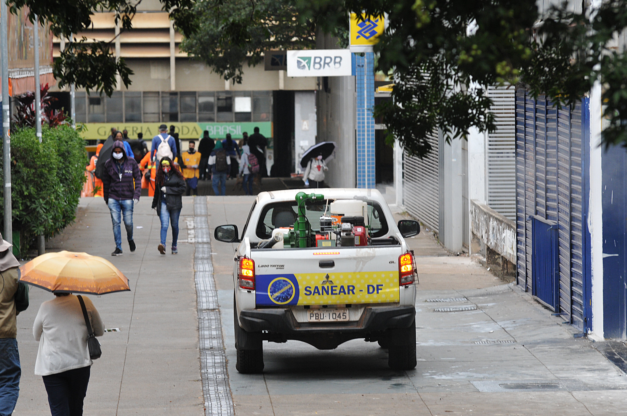 Registro do Setor Comercial Sul com pessoas caminhando e, ao lado, um veículo da SANEAR-DF