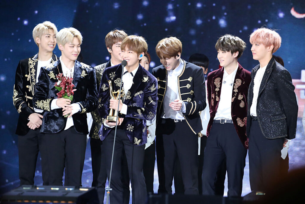 Integrantes do grupo BTS no palco recebendo um prêmio