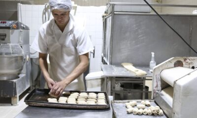 Padeiro produz pequenos pães na cozinha da padaria (matéria sobre MEI)