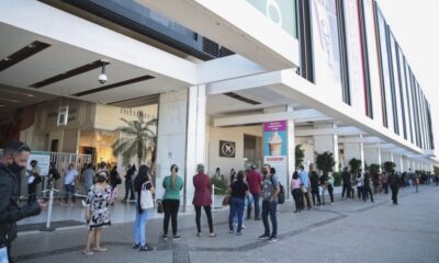 Fila de pessoas em frente ao shopping Conjunto Nacional ilustrando a reabertura do local com horário prolongado.