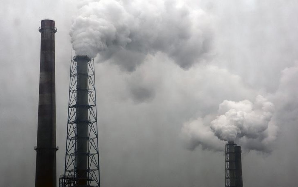 Registro de emissões realizadas por indústrias com um céu cinza de fundo