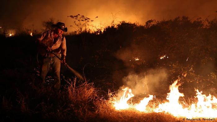 Homem apagando fogo de queimadas em Mato Grosso