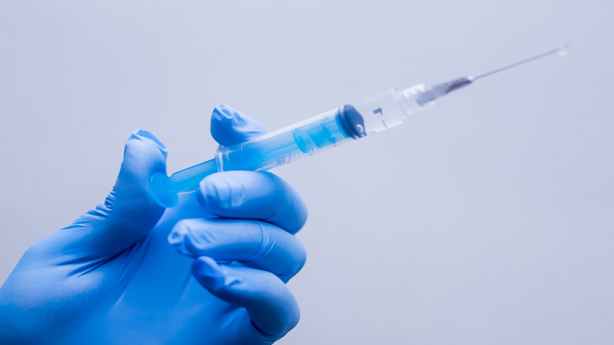 mão de médico manuseando vacina